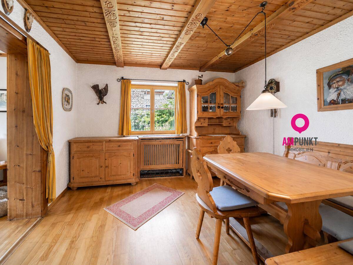 Traditioneller Essbereich mit Holztisch, Stühlen und einer Holzdecke im Landhausstil.