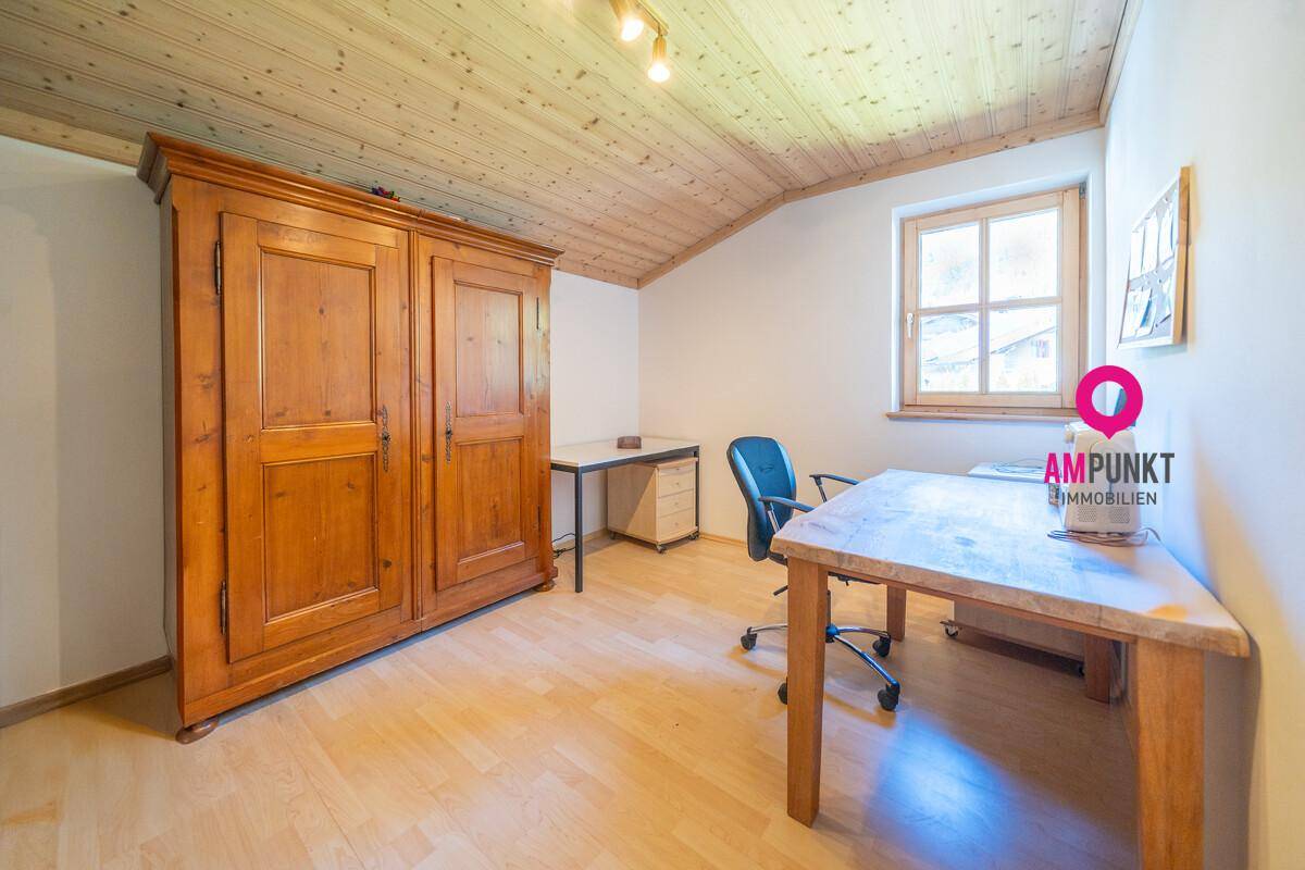 Ruhiges Arbeitszimmer mit Holzboden, Holzdecke und Fenster mit Blick ins Grüne.