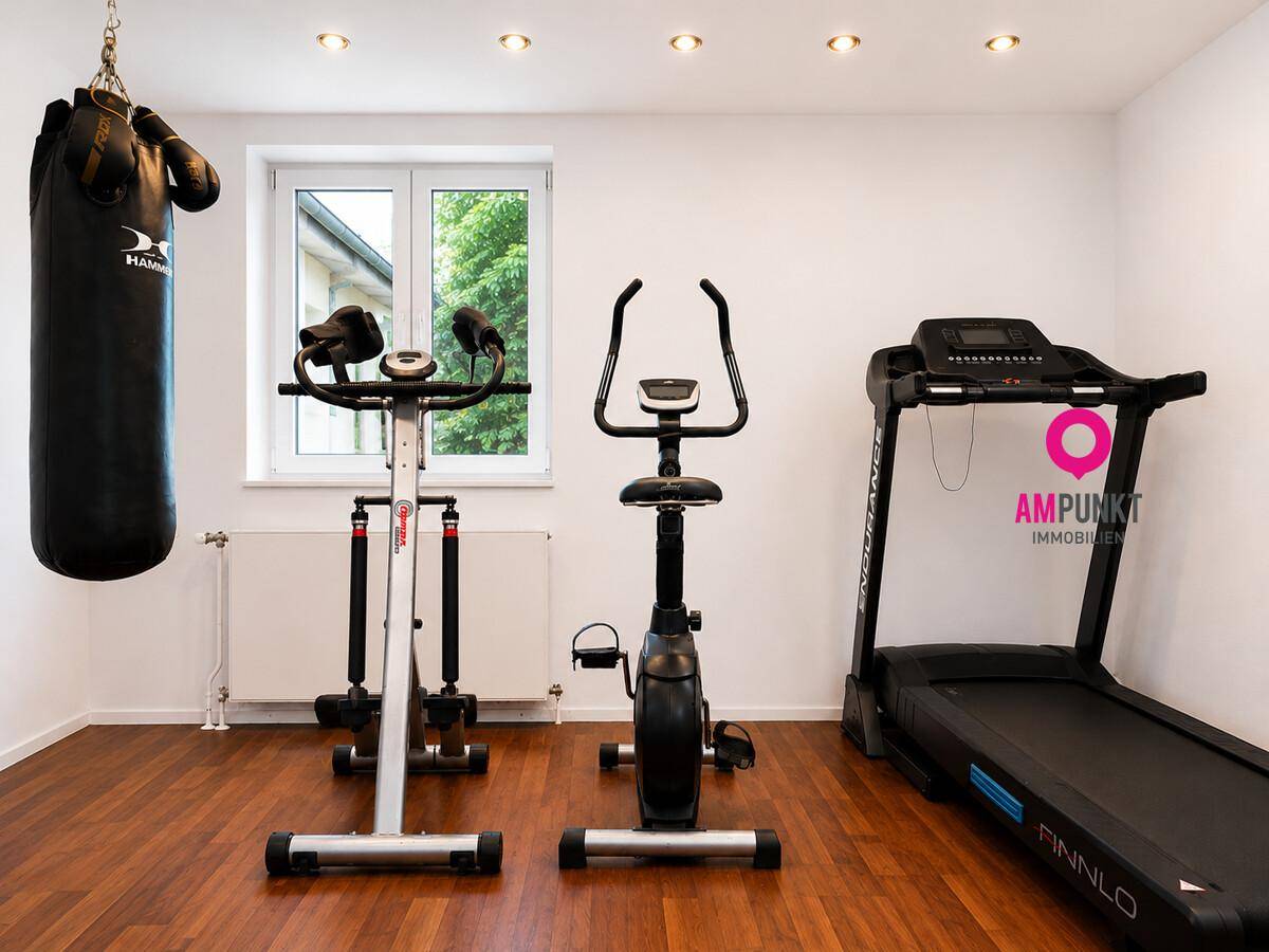 Fitnessraum mit Laufband, Heimtrainer und Boxsack für das persönliche Training zu Hause.