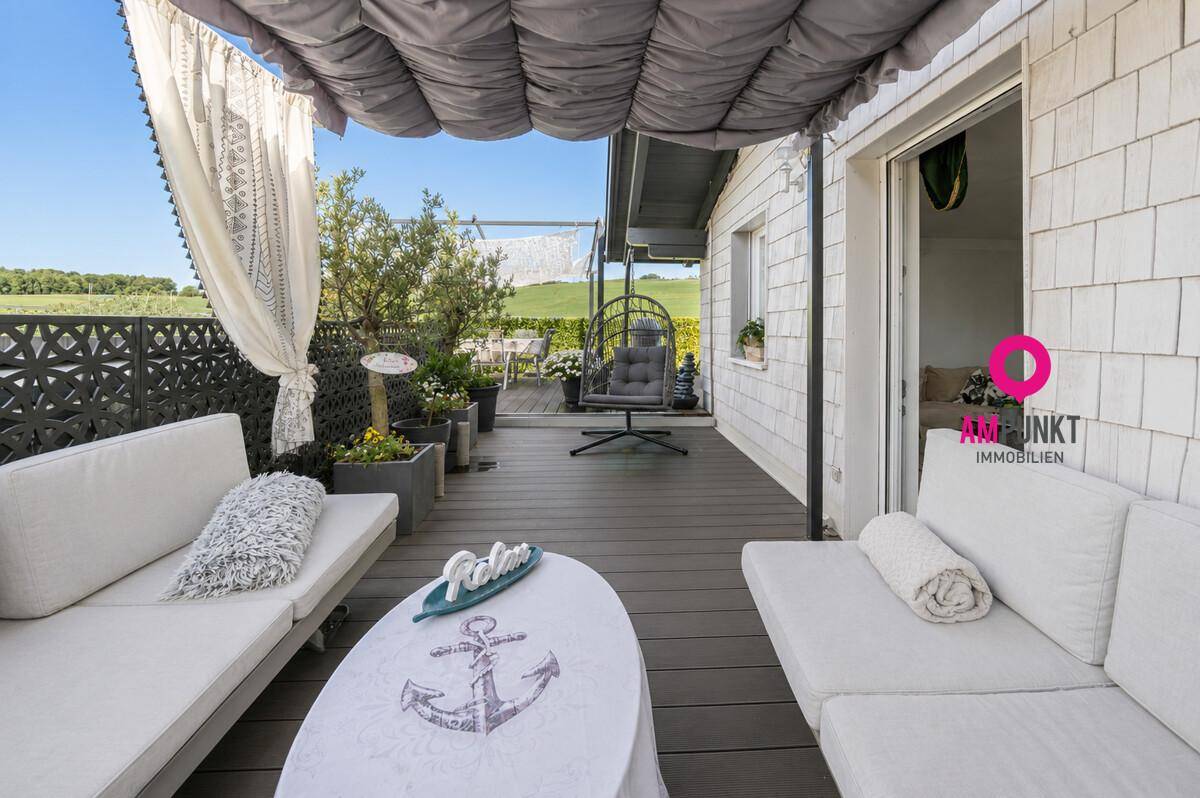 Gemütliche Terrasse mit Lounge-Möbeln und Sonnenschutz, perfekt für entspannte Stunden.