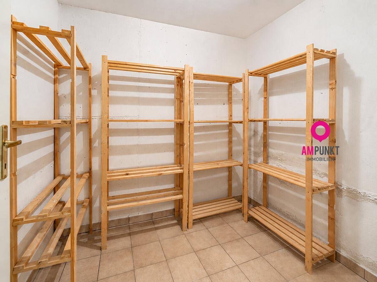Praktischer Abstellraum im Keller mit Holzregalen für zusätzlichen Stauraum.