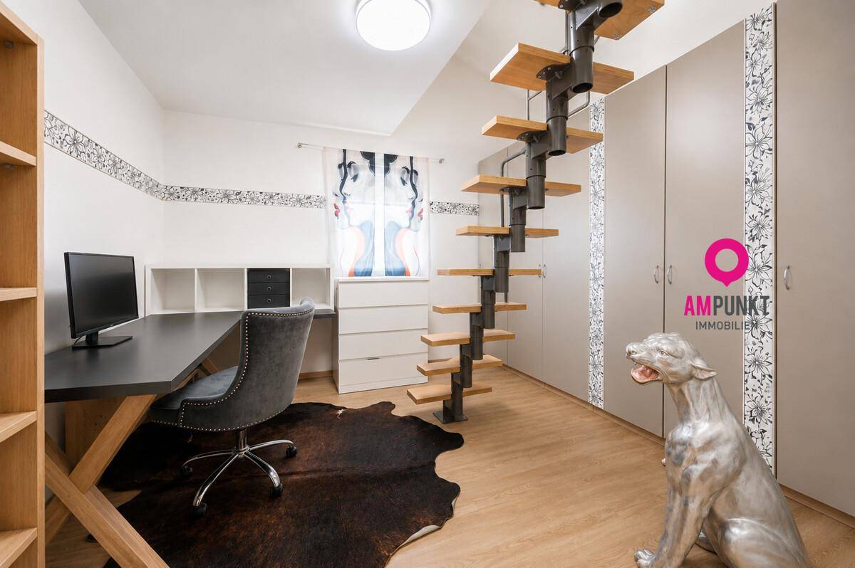 Modernes Arbeitszimmer mit Schreibtisch, Einbauschränken und einer Wendeltreppe.