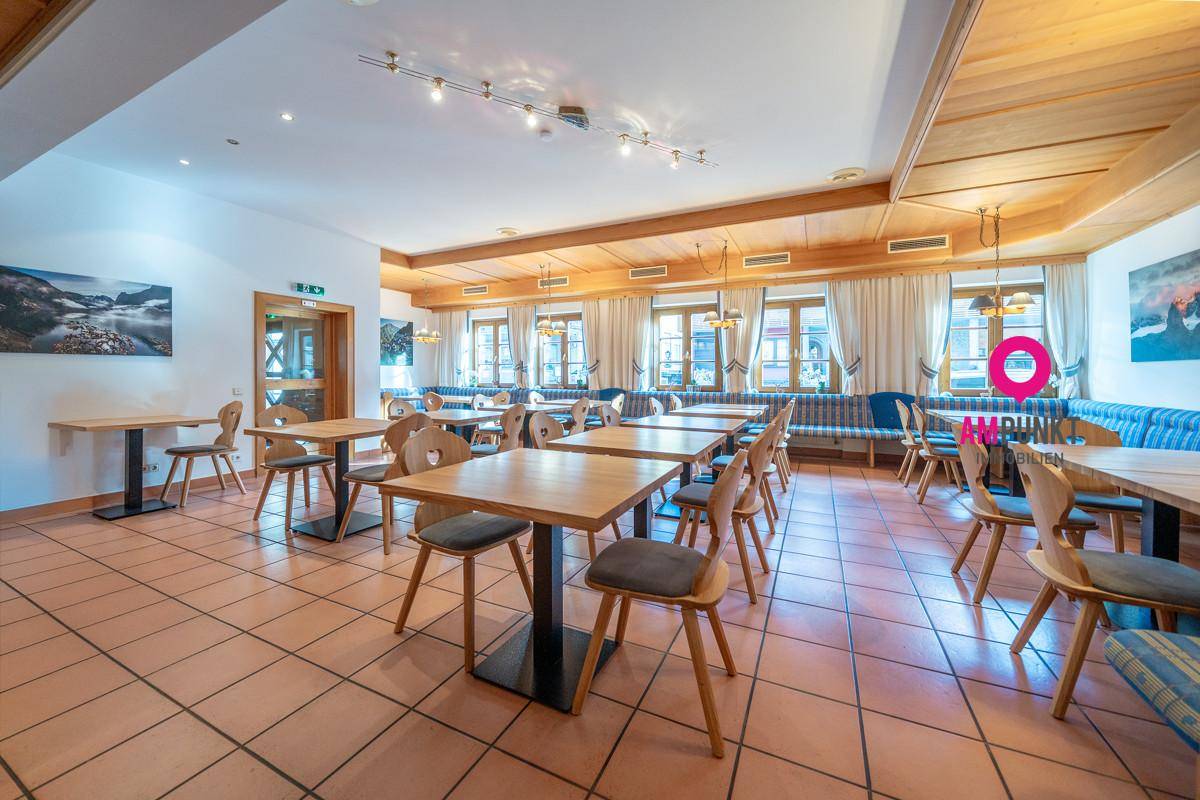 Großer Speisesaal mit zahlreichen Holztischen und Stühlen, gefliestem Boden und traditioneller Einrichtung, hell und einladend.
