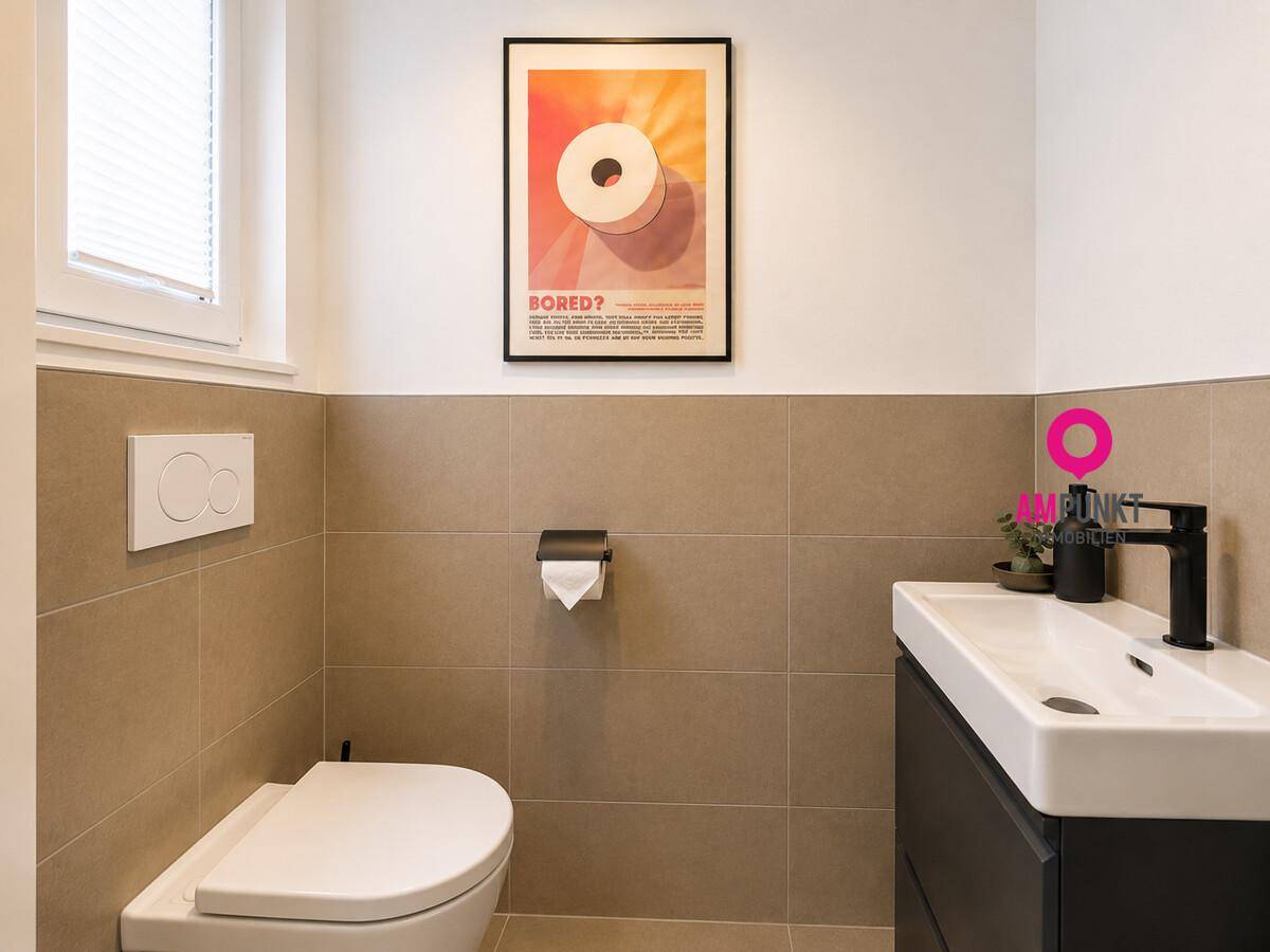 Modernes Gäste-WC mit beigefarbenen Fliesen, wandhängendem WC und kleinem Waschbecken.