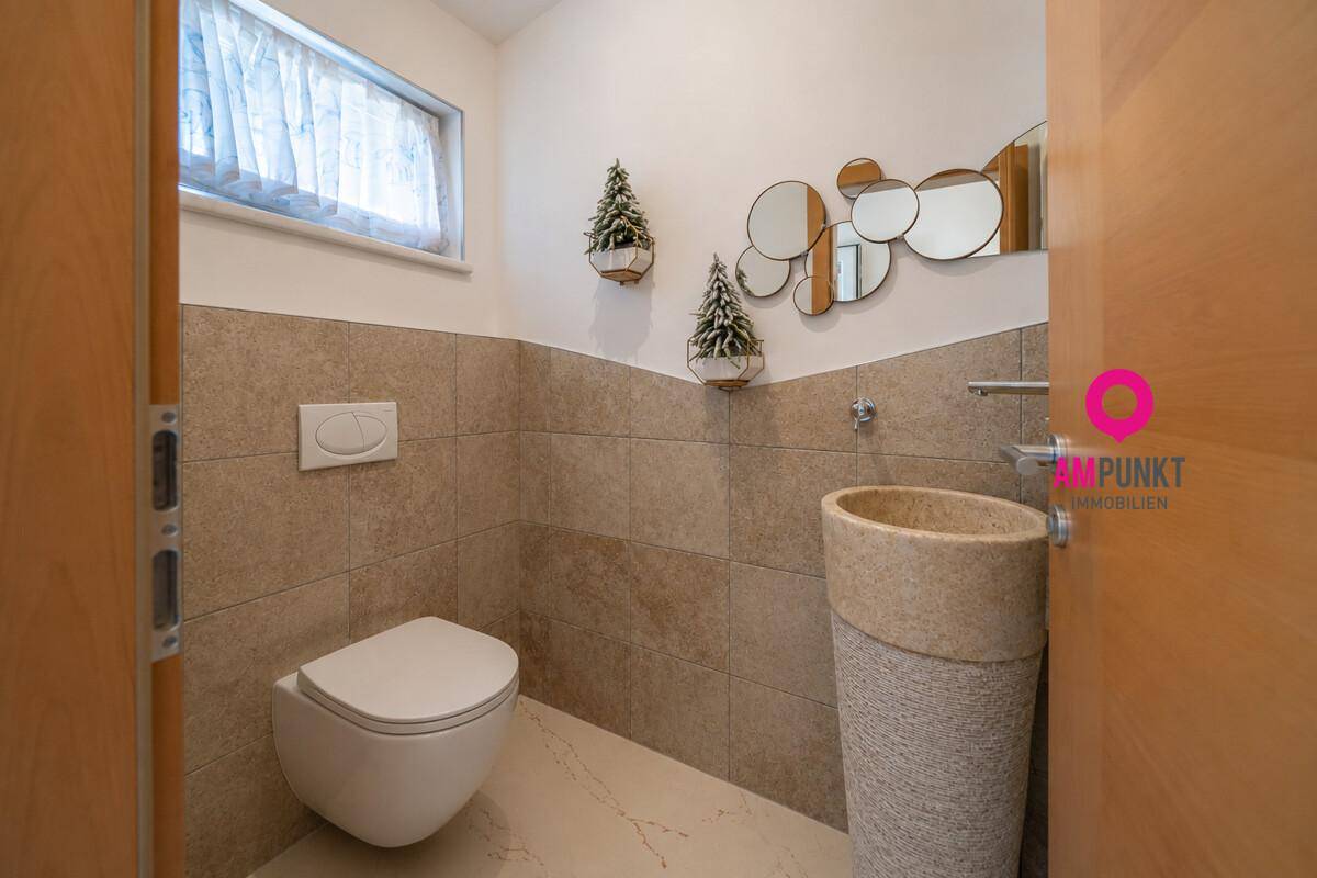Modernes Gäste-WC mit Wand-WC, stilvollem Waschbecken und dekorativen Spiegeln.