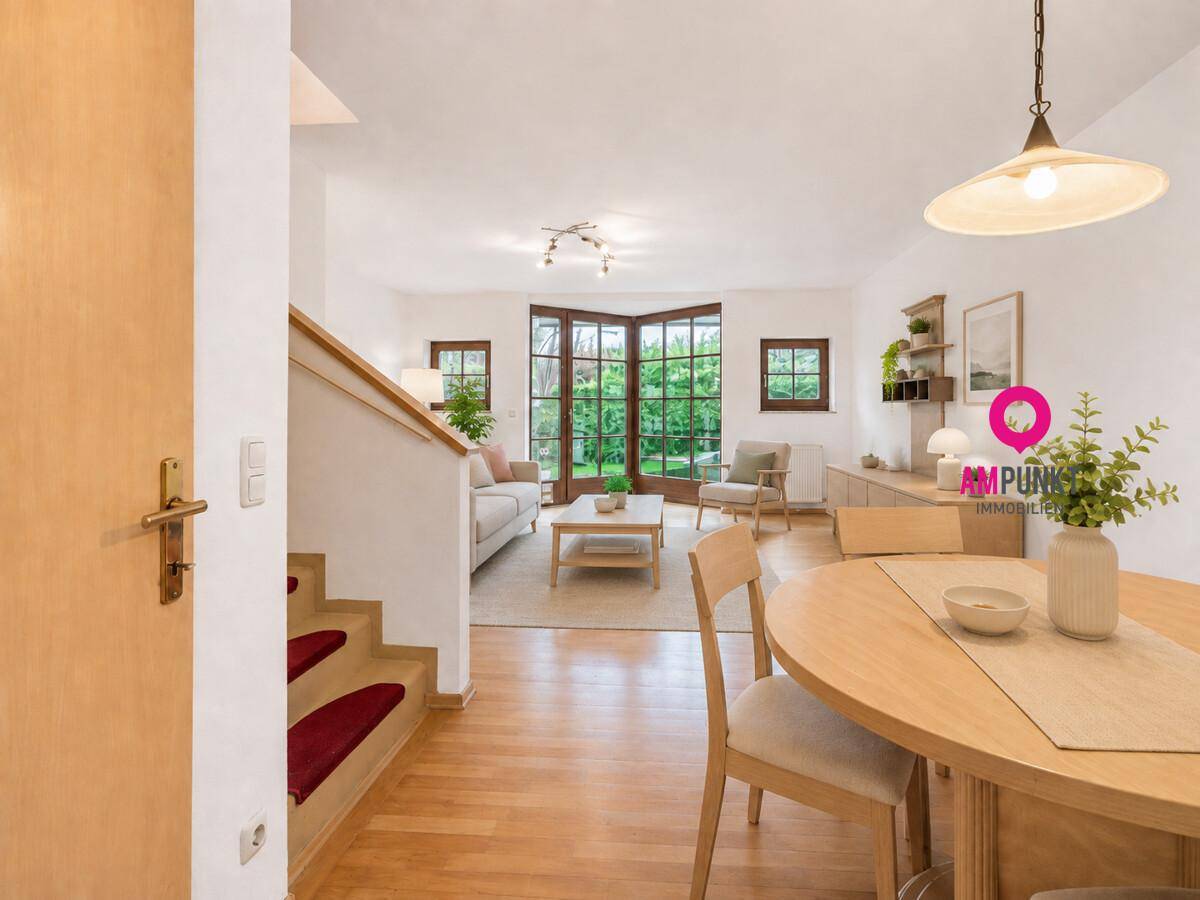 Heller Wohn- und Essbereich mit Parkettboden, Sofa und Esstisch, mit Zugang zum Garten.