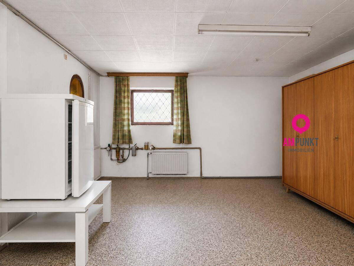 Geräumiger Kellerraum mit Fenster, Schrank und zusätzlichem Kühlschrank.