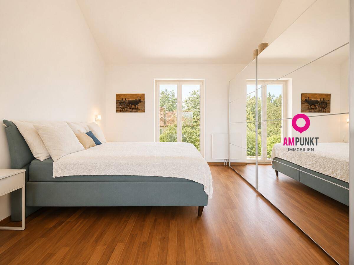 Geräumiges Schlafzimmer mit Holzboden, großem Bett und Spiegelschränken.