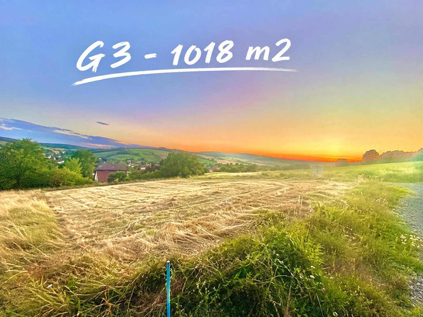 Weitläufiges Baugrundstück G3 mit Blick auf die malerische Landschaft und den Sonnenuntergang.
