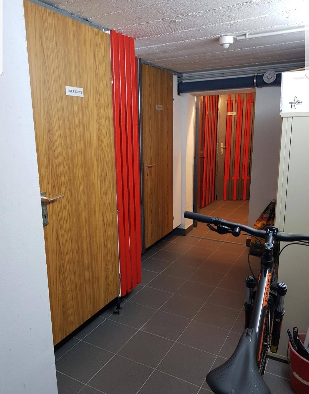 Kellerraum mit mehreren Abteilen und einem Fahrrad, ideal als Stauraum für Bewohner.