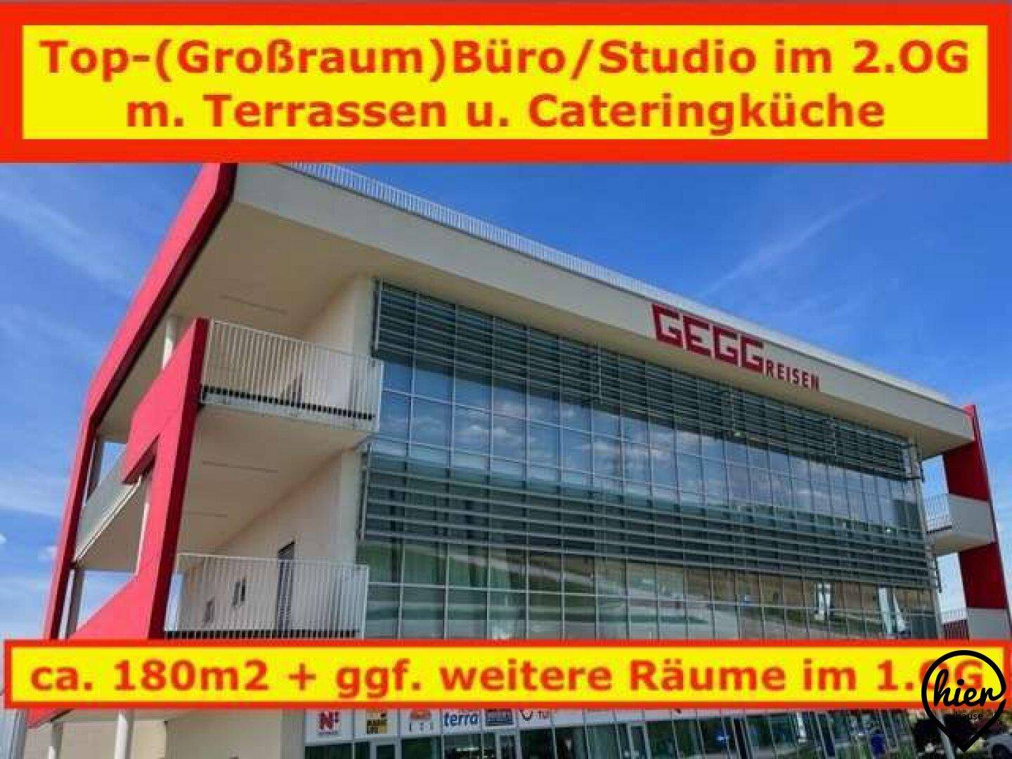 Modernes Geschäftsgebäude mit roter Fassade, großen Glasflächen und Balkonen.