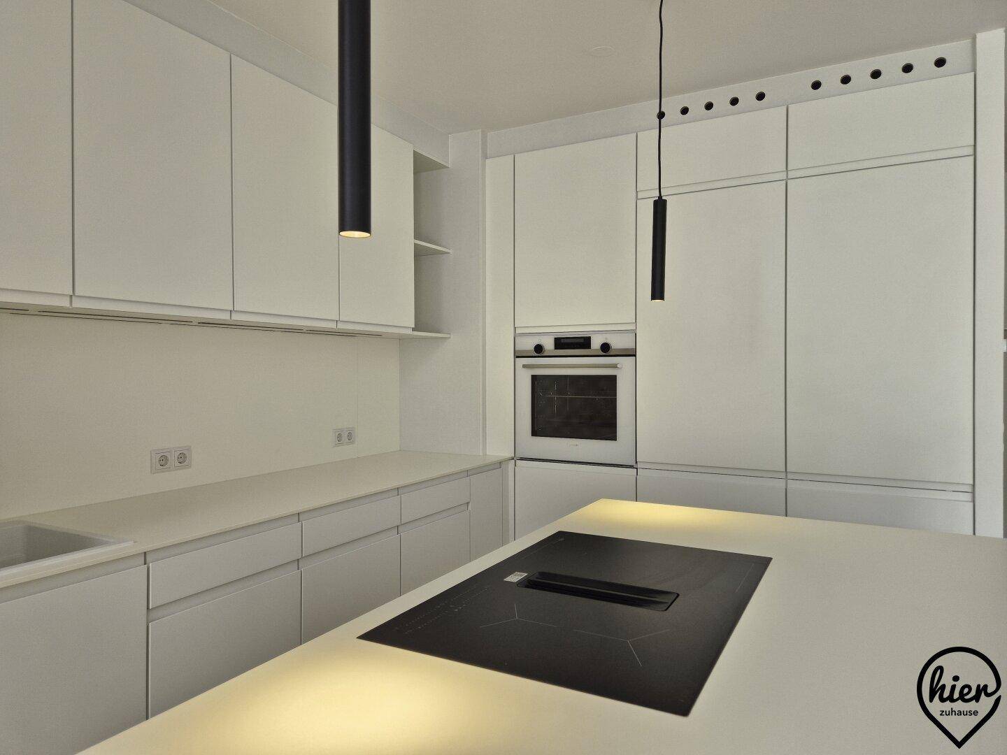 Detailansicht der modernen weißen Küche mit integriertem Induktionskochfeld und Backofen.