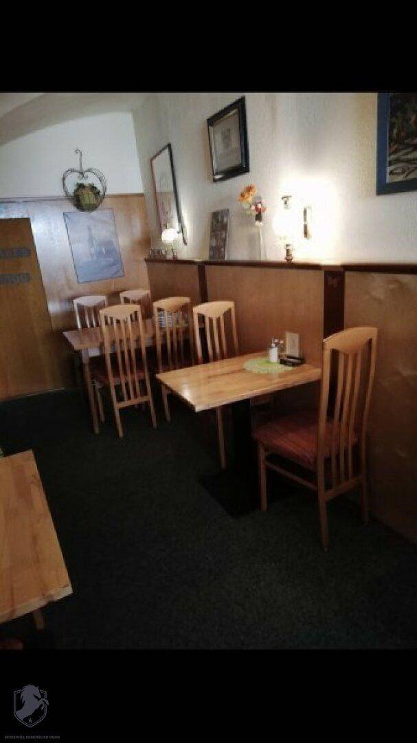 Speisesaal in traditionellem Ambiente mit Holztischen und Stühlen, bereit für Gäste.