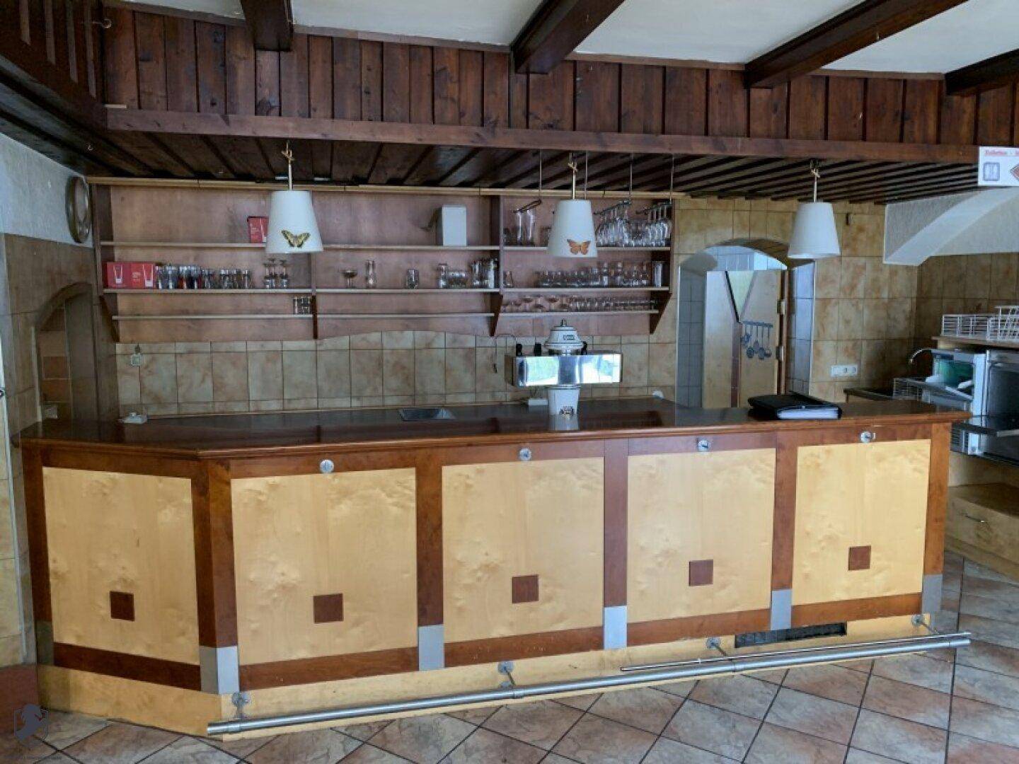 Holzbar mit Regalen für Gläser und Flaschen, bereit für den Service.