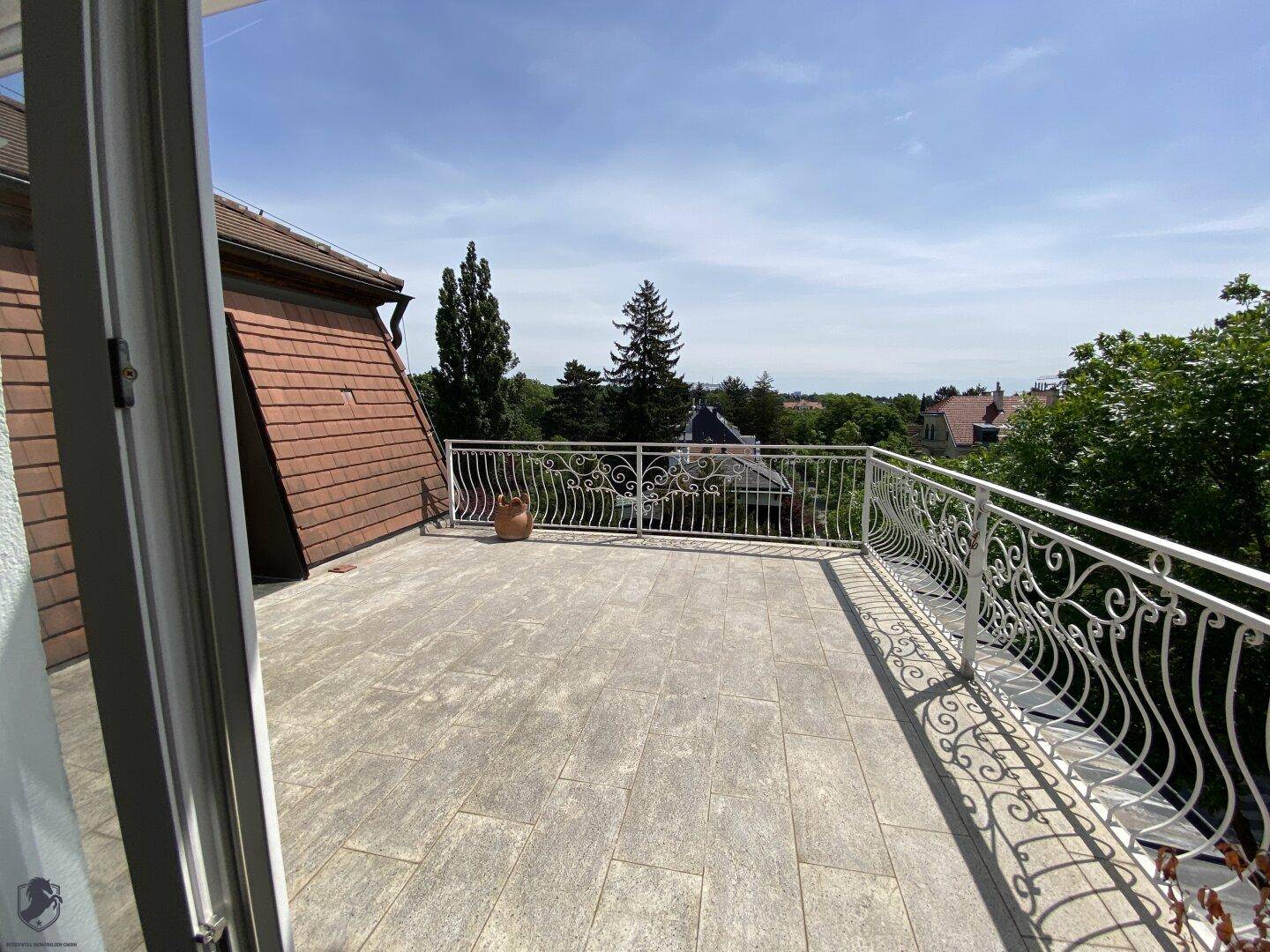 Geräumige Dachterrasse mit Fliesenboden und schmiedeeisernem Geländer, bietet weite Aussicht.