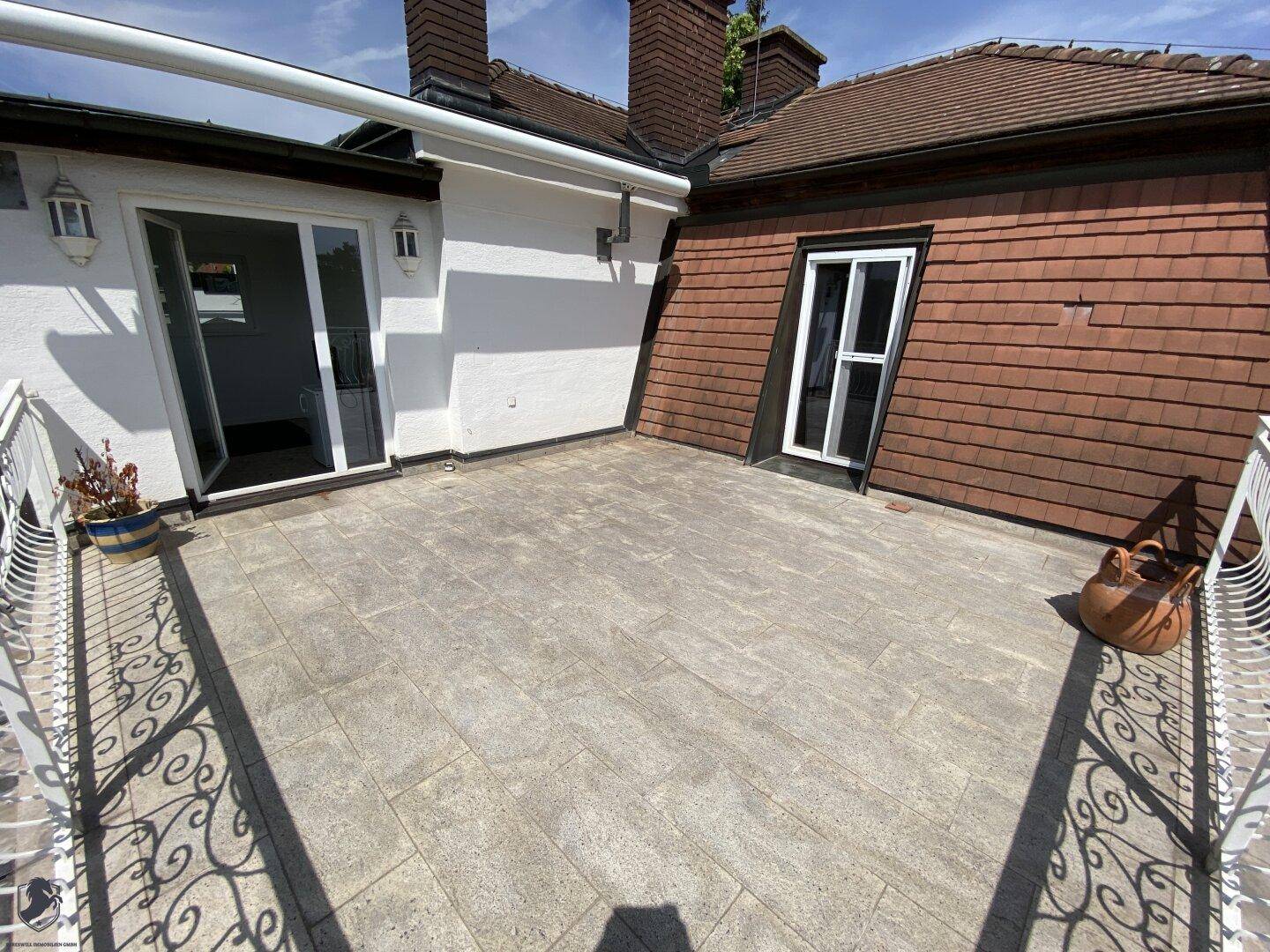 Dachterrasse mit Fliesenboden, Ziegeldach und Zugang zu Innenräumen, bietet viel Platz.