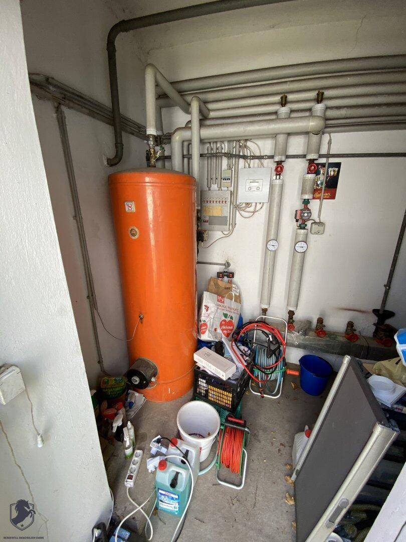 Heizungsraum mit Warmwasserspeicher, Rohren und Heizungsanlage, dient als Technikraum.