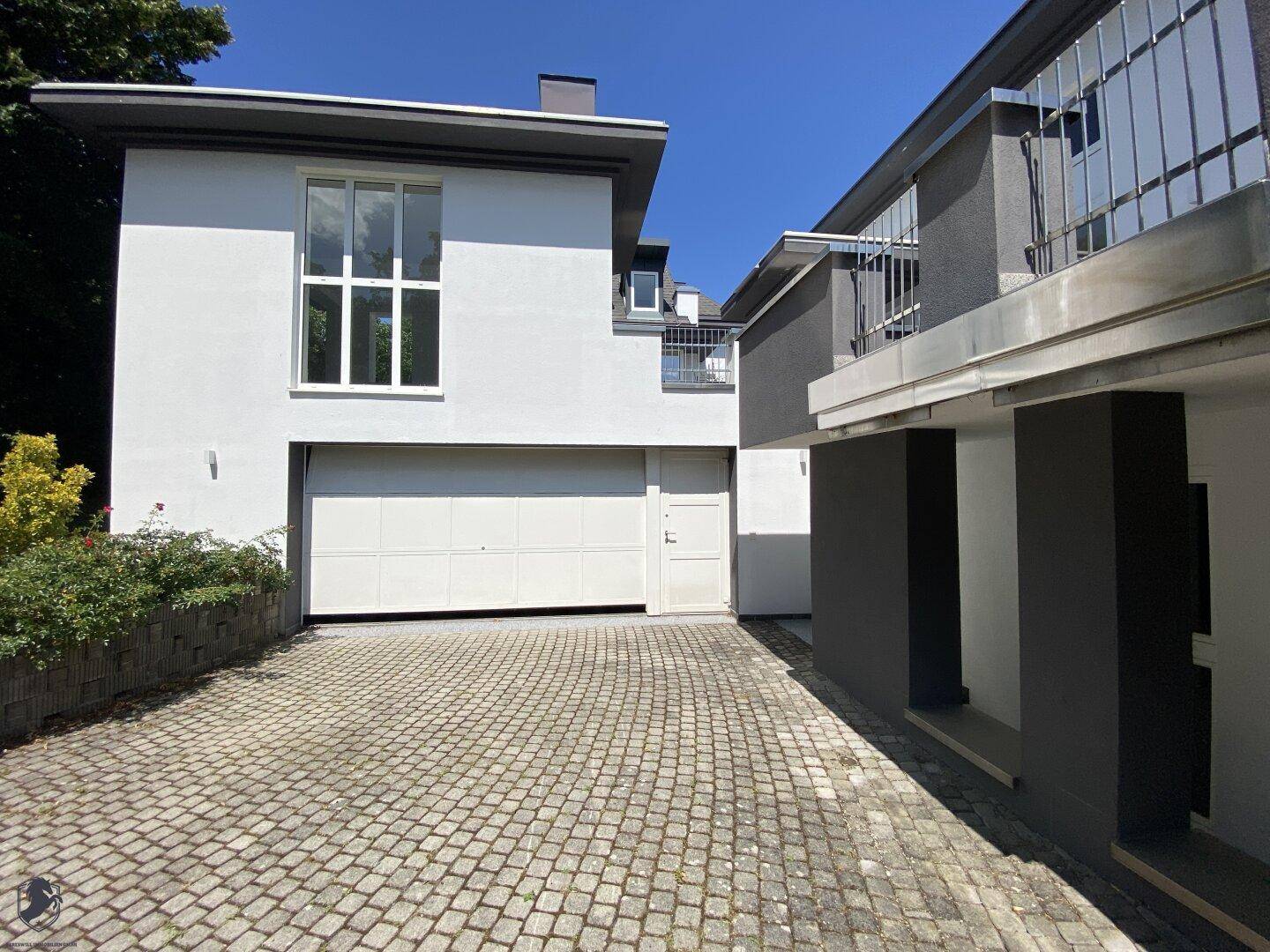 Gepflasterte Auffahrt führt zu einer Doppelgarage und dem Eingangsbereich des Hauses.