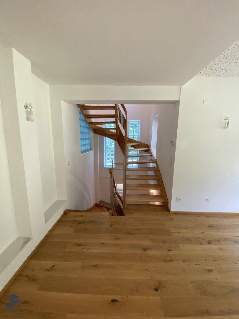 Helle Diele mit Holztreppe und Glasbausteinen, die für natürliches Licht sorgen.