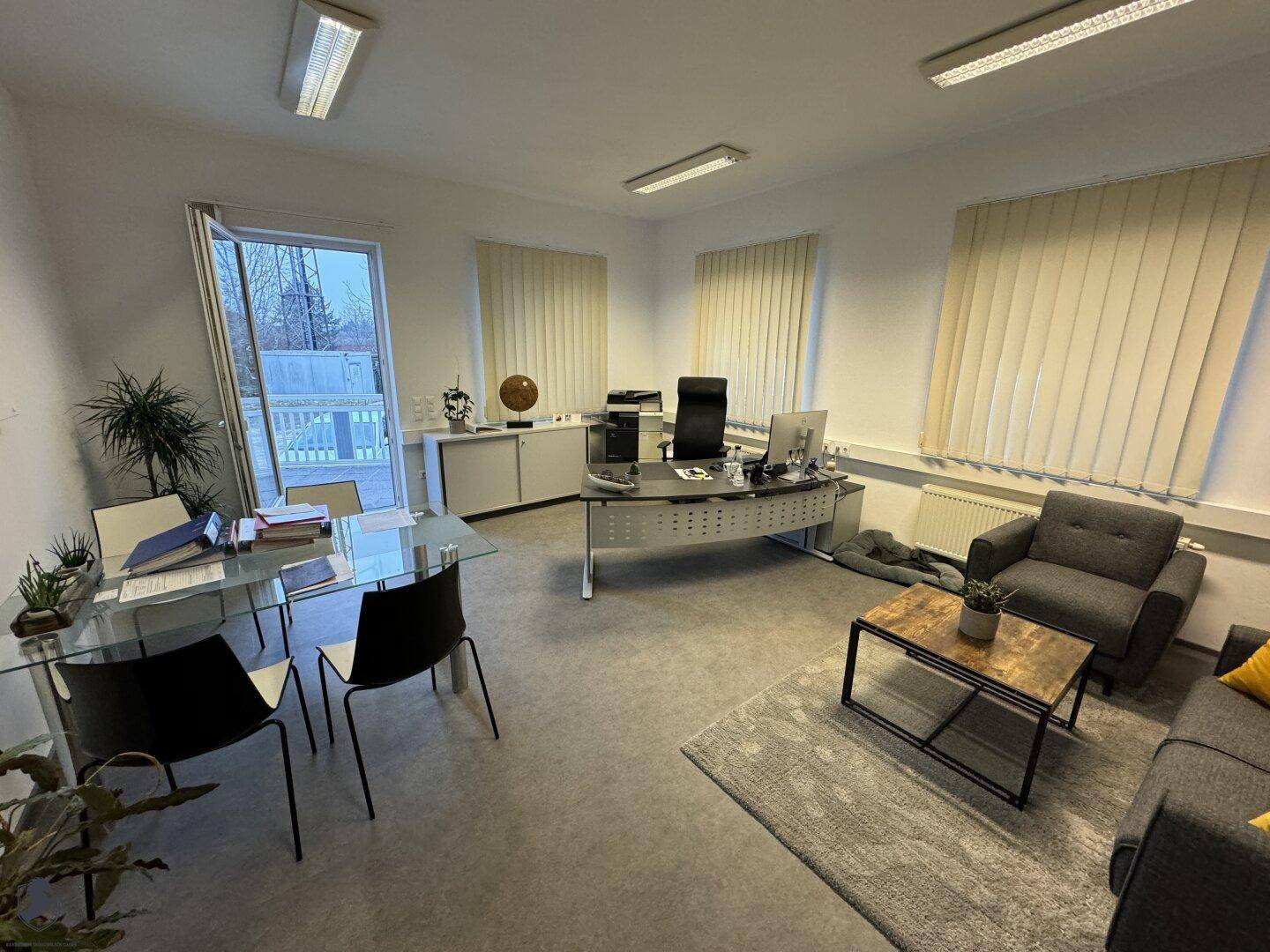 Helles Büro mit Schreibtisch, Sitzbereich und direktem Zugang zur Außenterrasse, ideal für Pausen.