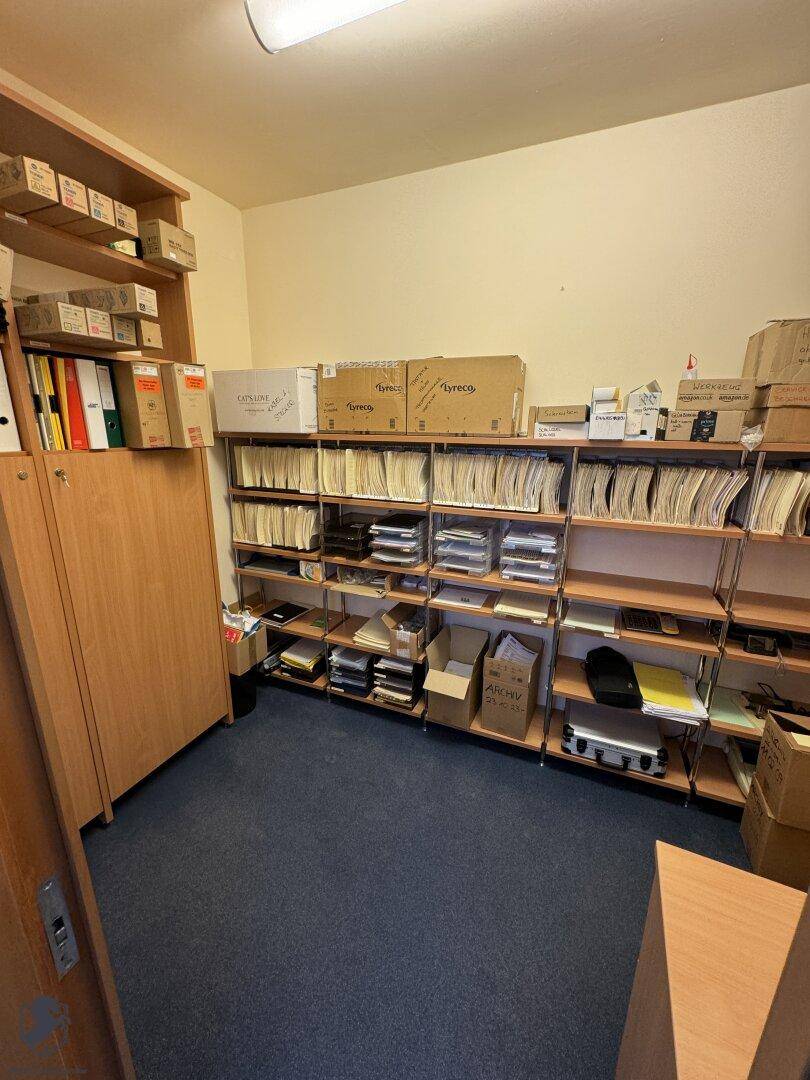 Organisierter Abstellraum mit Regalen voller Aktenordner und Kartons, ideal für Archivierung.