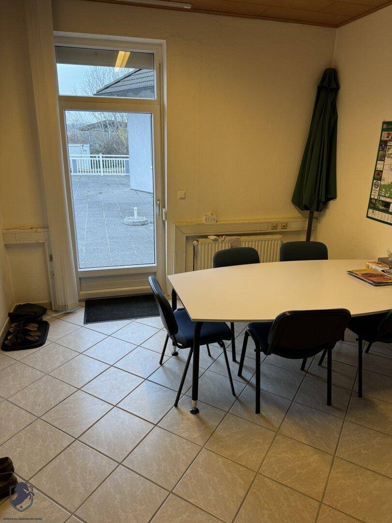 Kleiner Ess- oder Pausenraum mit Tisch, Stühlen und direktem Zugang zur Außenterrasse.