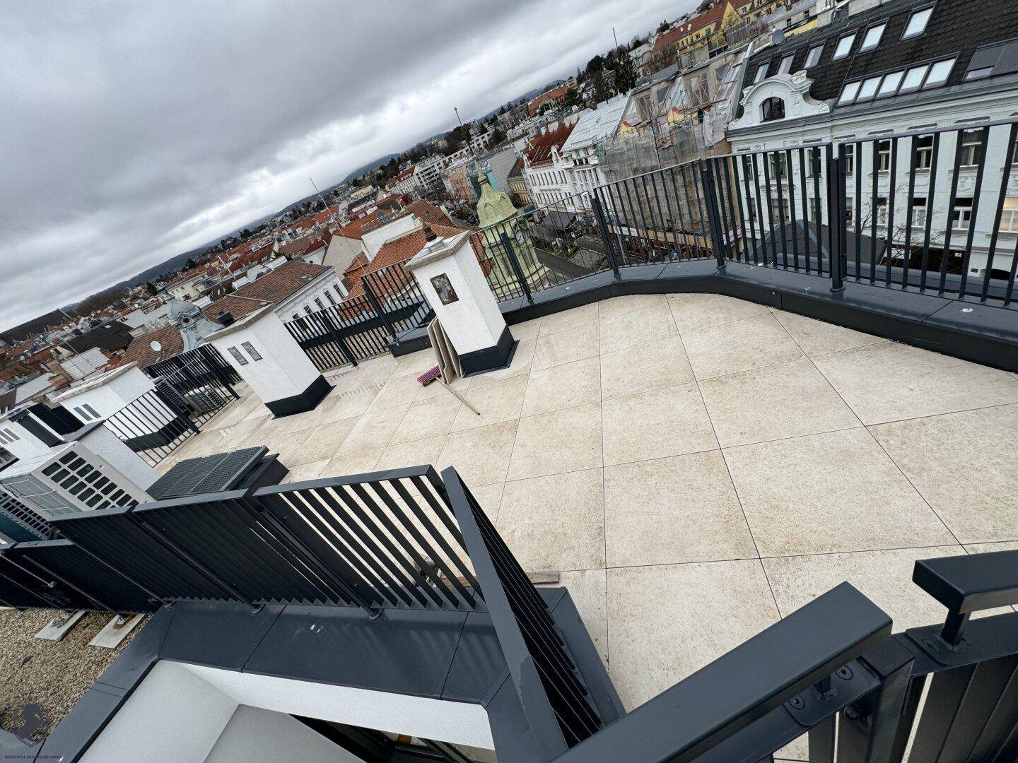Große Dachterrasse mit Panoramablick über die Stadt und umliegende Gebäude.