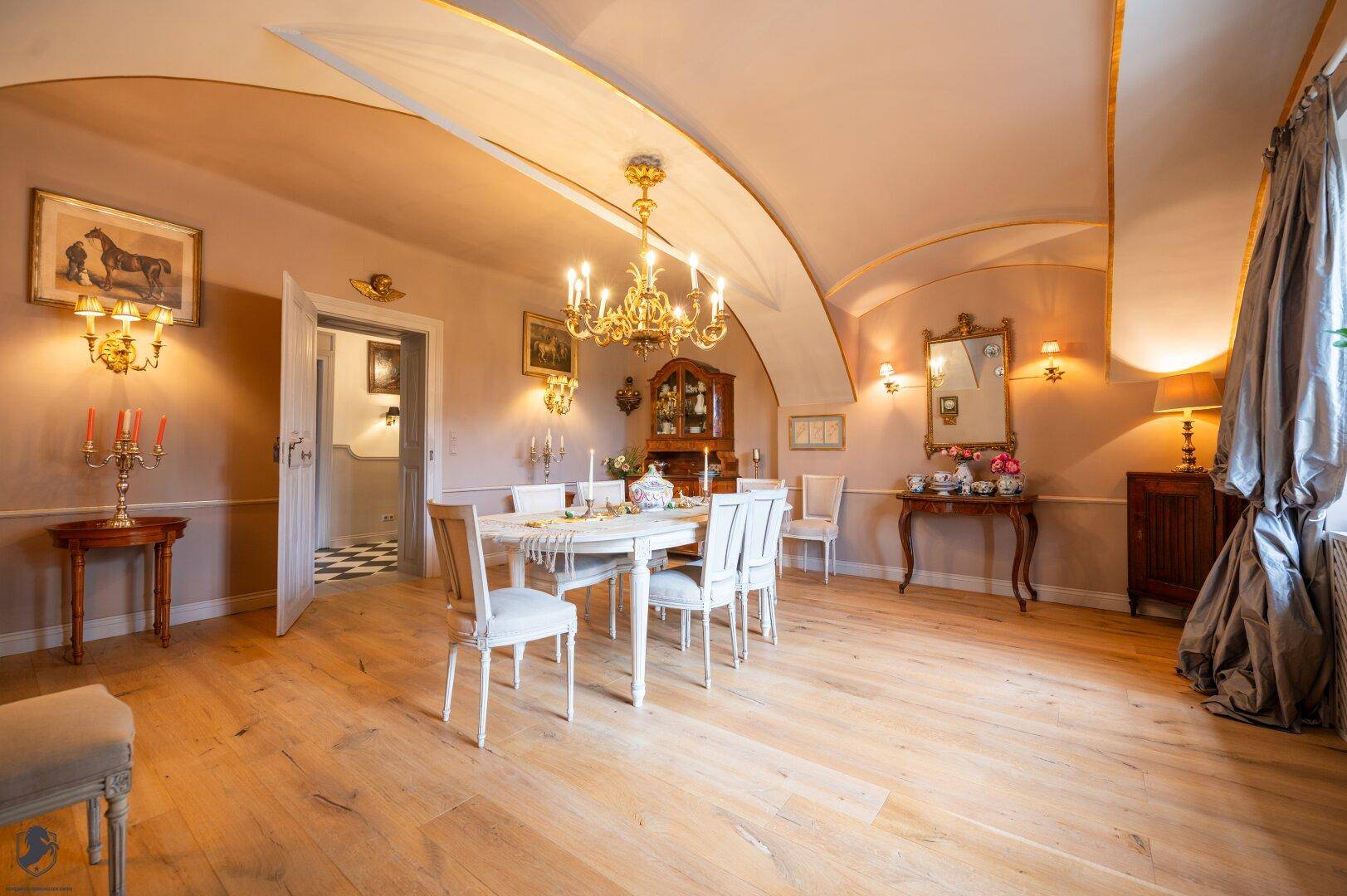 Geräumiger Essbereich mit elegantem Esstisch, Kronleuchter und beeindruckender Gewölbedecke.