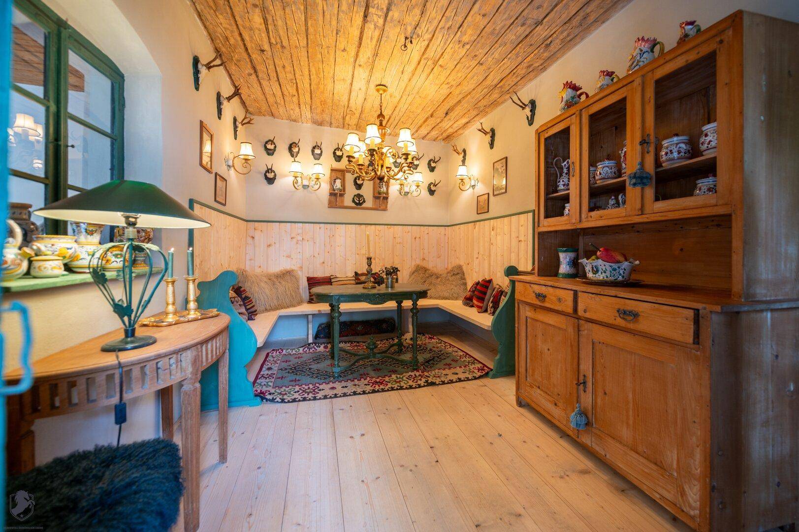 Gemütlicher Essbereich mit Holzvertäfelung, eingebauter Sitzbank und rustikaler Holzdecke.