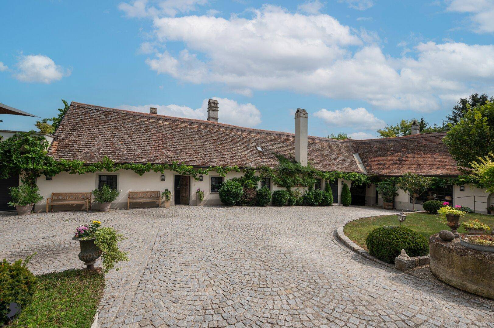 Historischer Innenhof mit Kopfsteinpflaster und einem weitläufigen Gebäudeensemble.