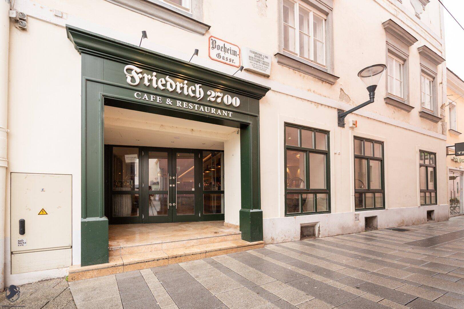 Eingangsbereich eines Cafés und Restaurants mit grüner Fassade und historischem Charme.