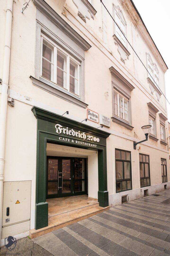 Historisches Gebäude mit markantem Eingangsbereich und Fenstern in der Stadt.