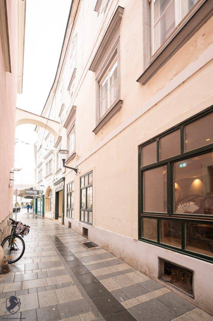 Schmale Gasse mit Kopfsteinpflaster und historischen Gebäuden in der Stadt.