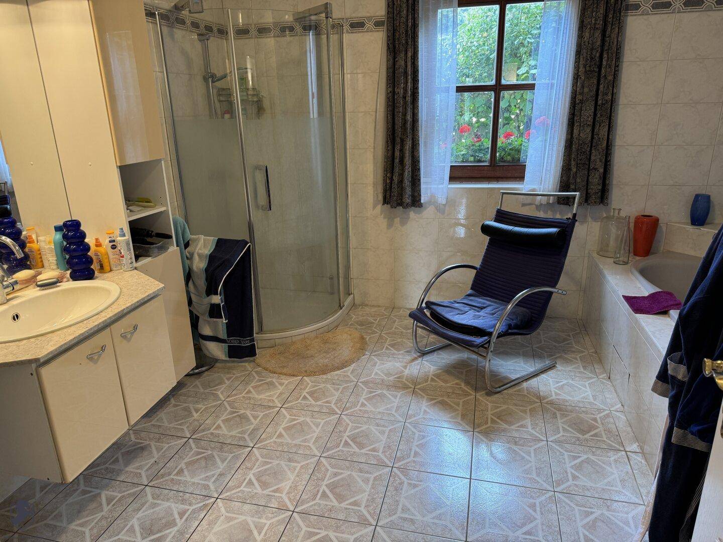 Geräumiges Badezimmer mit Duschkabine, Badewanne, Waschbecken und Fenster.