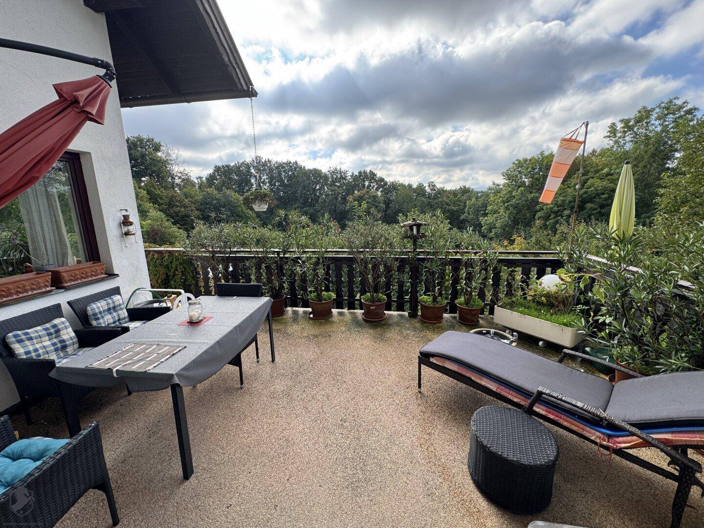 Große Terrasse mit Gartenmöbeln, Sonnenliege und weitem Blick ins Grüne.