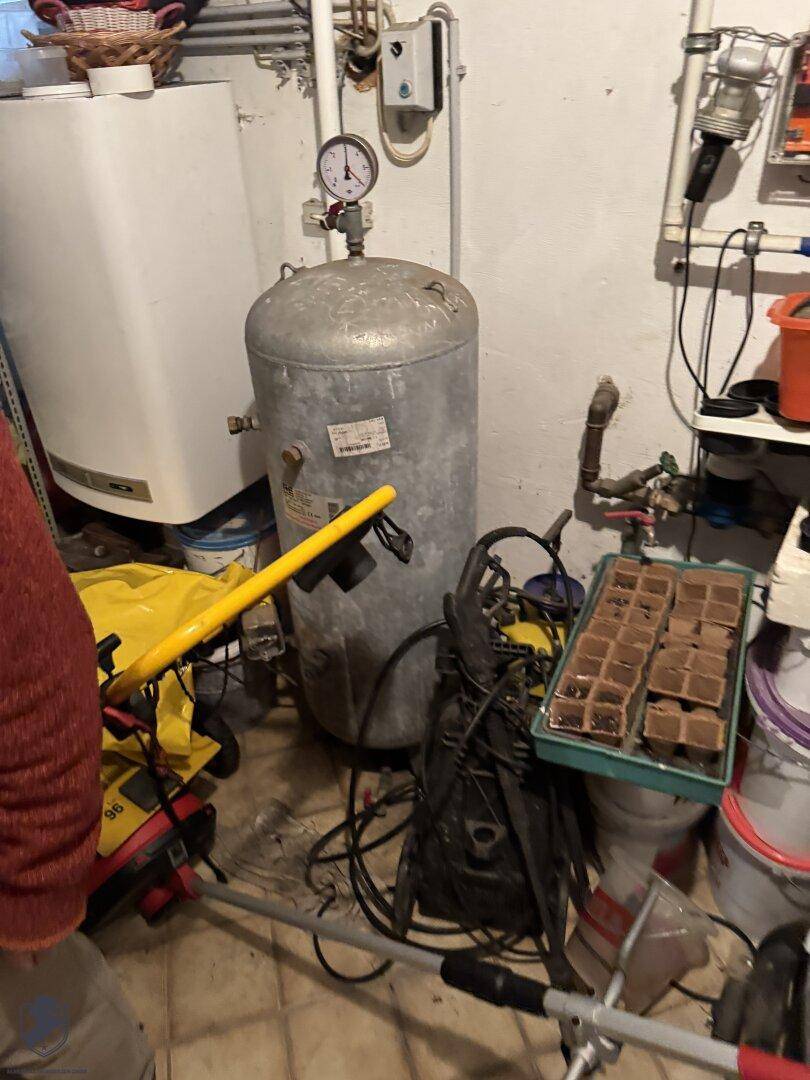 Hauswirtschaftsraum mit Warmwasserboiler, Rohren und verschiedenen Geräten.