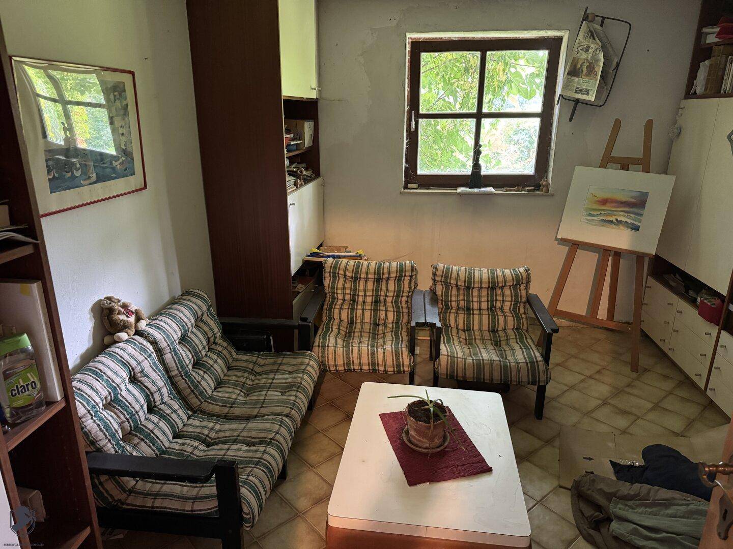 Kleiner Wohnbereich oder Büro mit Sofa, Sesseln und Blick ins Grüne.