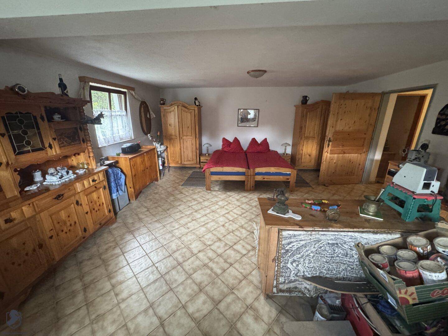 Schlafzimmer mit zwei Einzelbetten, Holzmöbeln und Fliesenboden.