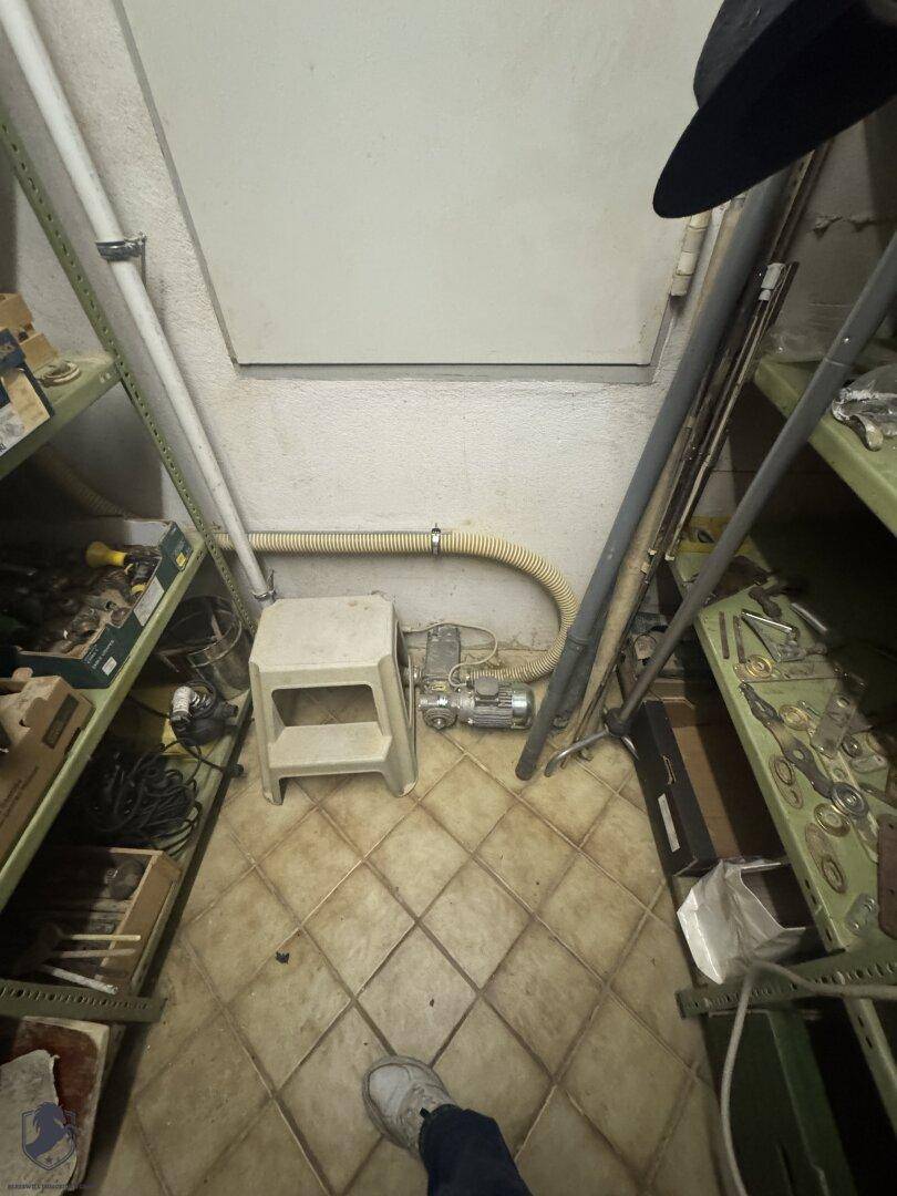 Kleiner Abstellraum mit Regalen und Fliesenboden für Lagerzwecke.