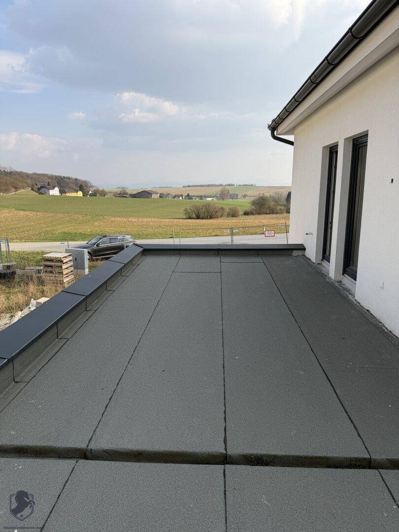 Flachdachbereich mit weitem Blick über die Landschaft, ideal für eine Dachterrasse.