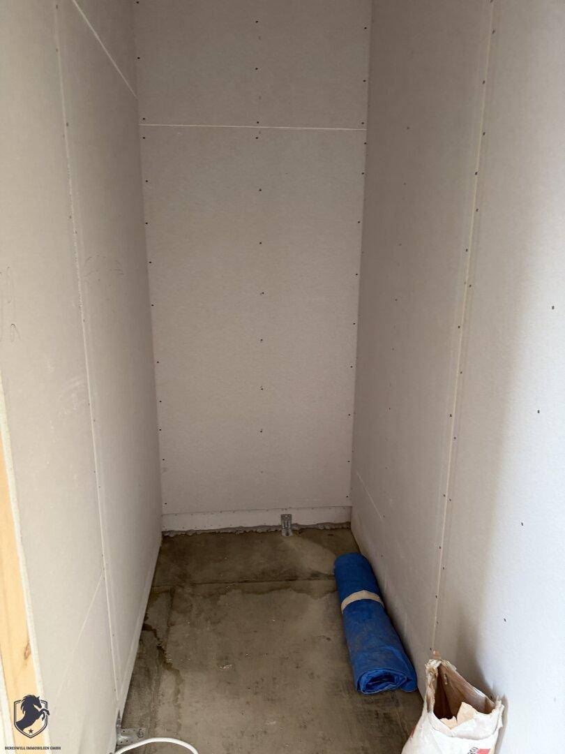 Kleiner Abstellraum im Rohbau mit Baumaterialien und unfertigen Wänden.