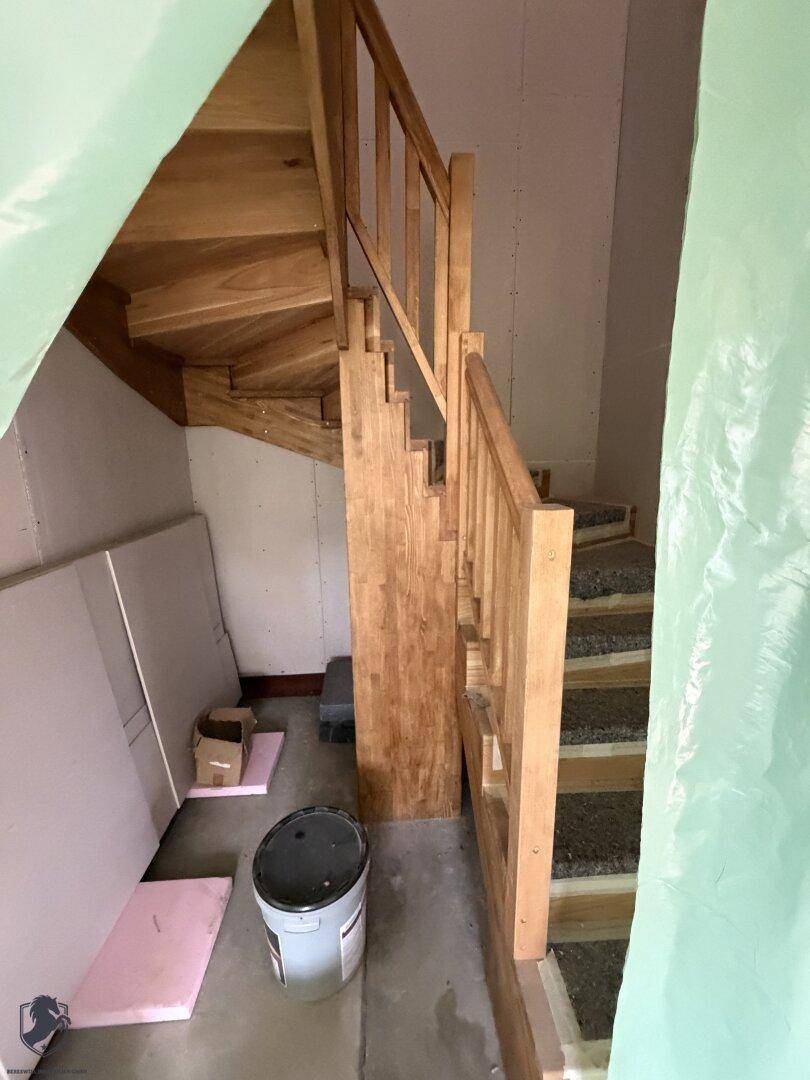 Holztreppe im Rohbau mit Schutzabdeckung auf den Stufen.