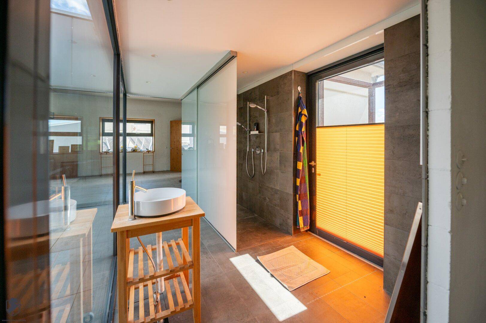 Modernes Badezimmer mit Aufsatzwaschbecken, begehbarer Dusche und großem Fenster für viel Tageslicht.
