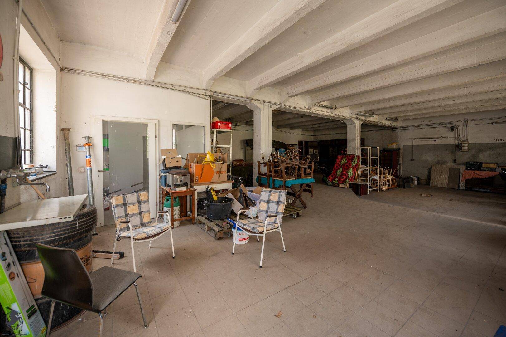 Weiterer Blick in den weitläufigen Industrieraum mit hohen Decken und einem Waschbeckenbereich.