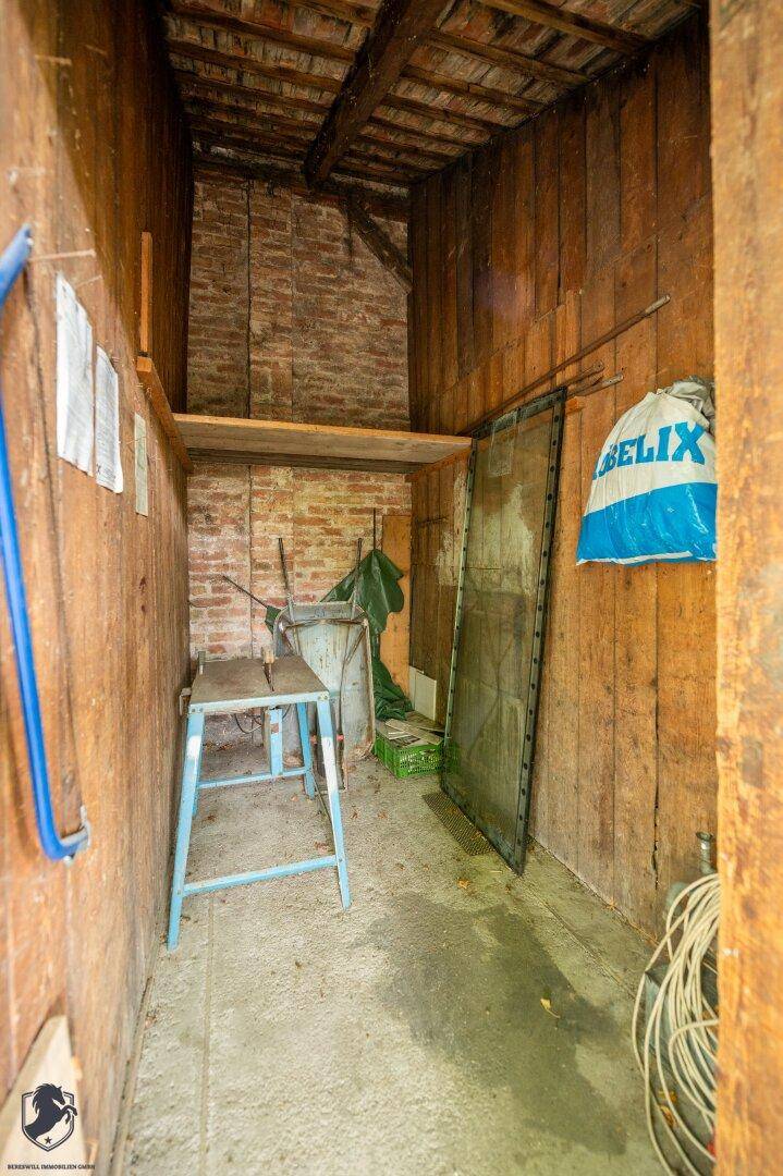 Einfacher Lagerraum mit Holzwänden und Ziegelmauerwerk, bietet zusätzlichen Stauraum.