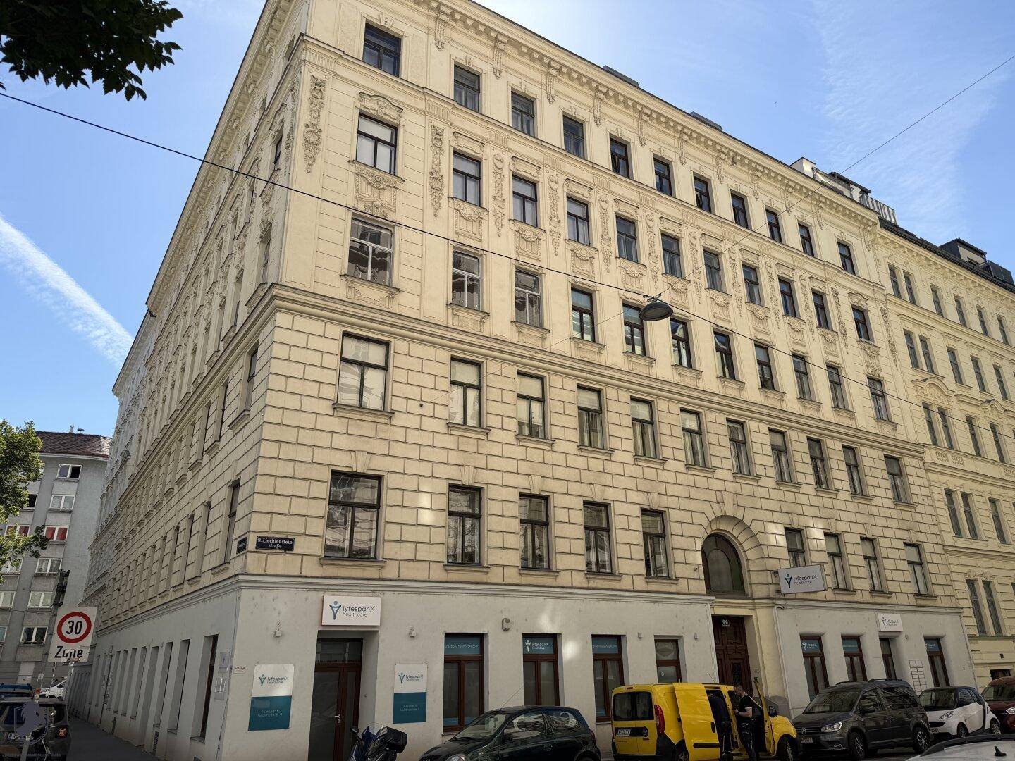 Historisches Eckgebäude mit klassischer Fassade und vielen Fenstern in urbaner Umgebung.