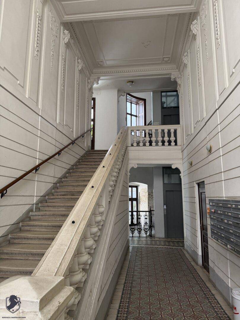 Prächtiges Treppenhaus mit kunstvollen Stuckverzierungen und Marmorbalustrade in einem Altbau.