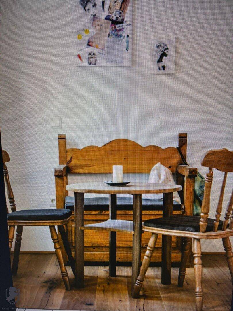 Kleiner Essbereich mit rustikaler Holzbank, Stühlen und einem runden Tisch.