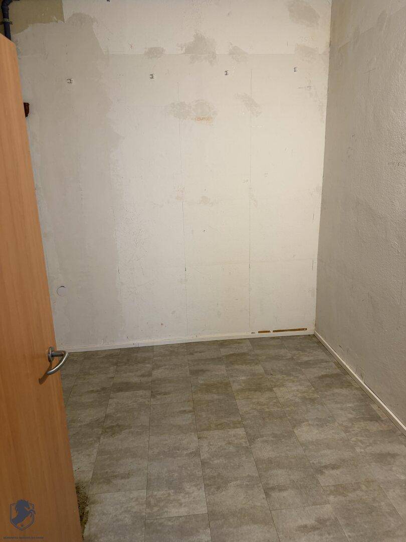 Kleiner Raum mit hellgrauem Fliesenboden und weißen Wänden, bereit für individuelle Gestaltung.