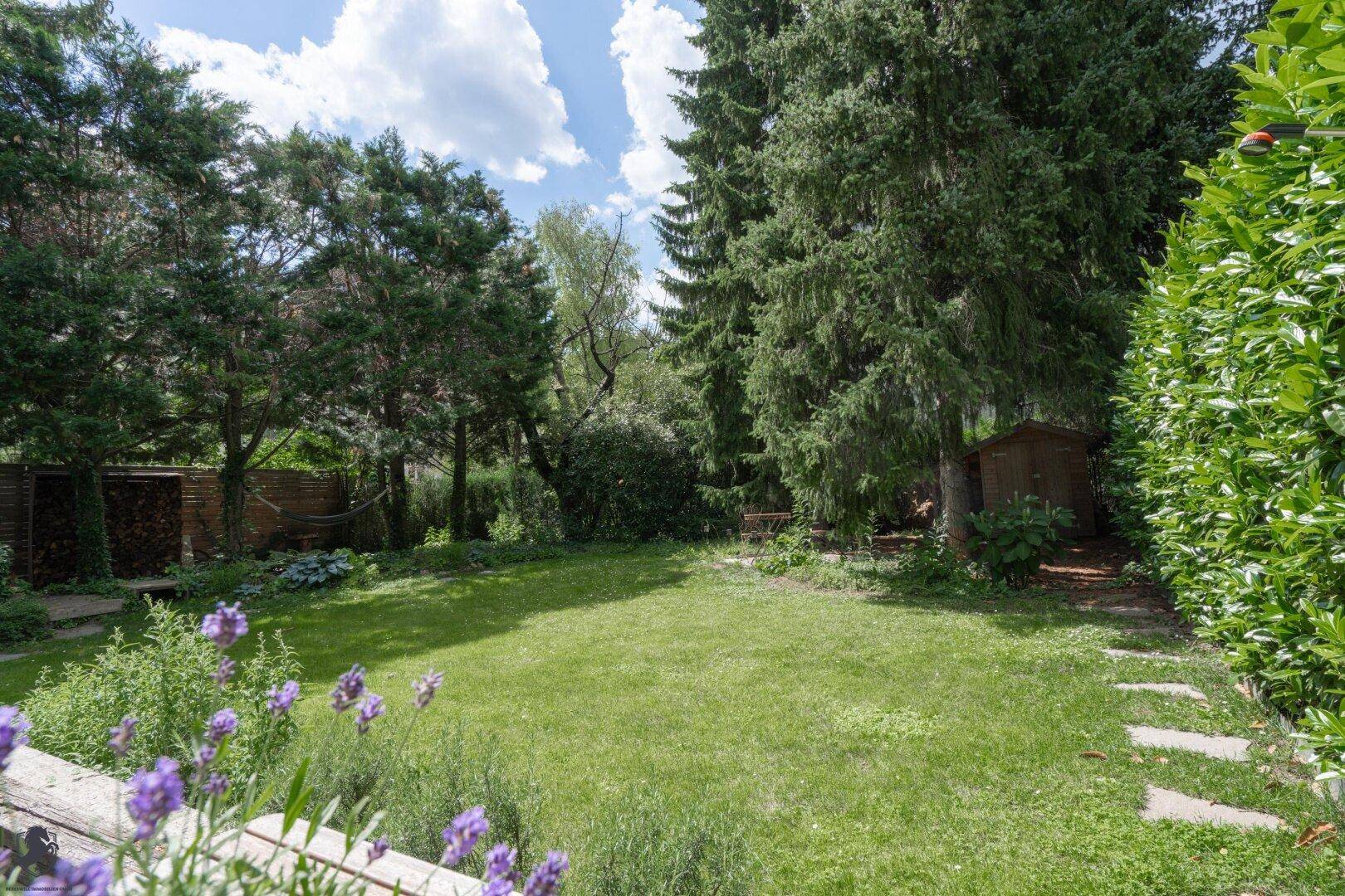 Großer, gepflegter Garten mit weitläufiger Rasenfläche und altem Baumbestand.